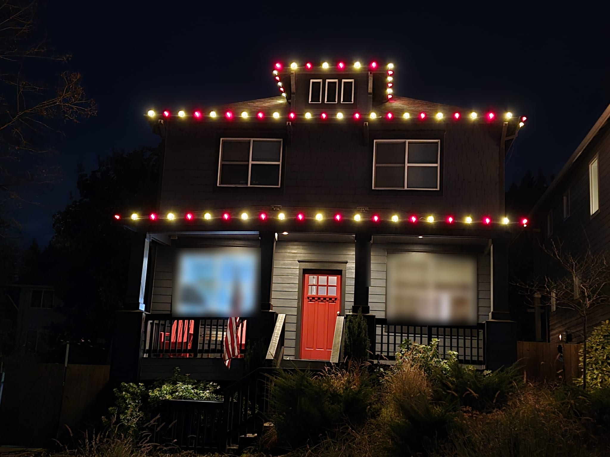 Two-storey home with alternating red and warm white C9 bulbs on the roofline, dormer and porch roof