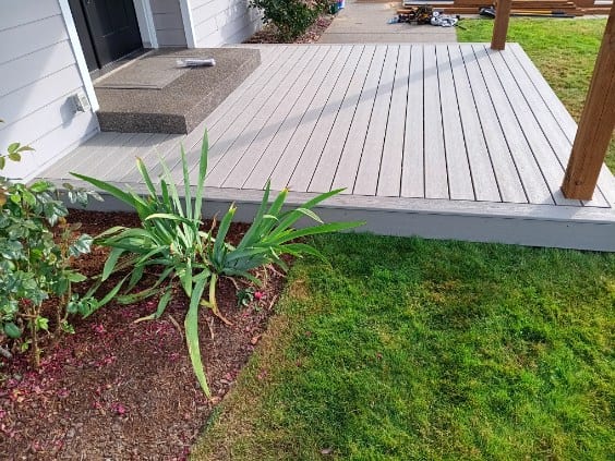Ground-level grey composite deck at a front entry, built by On Top Home Services and affiliates