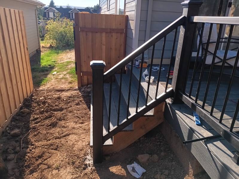 Cedar board-on-board fence and gate with a black aluminum stair rail, built by On Top Home Services and affiliates