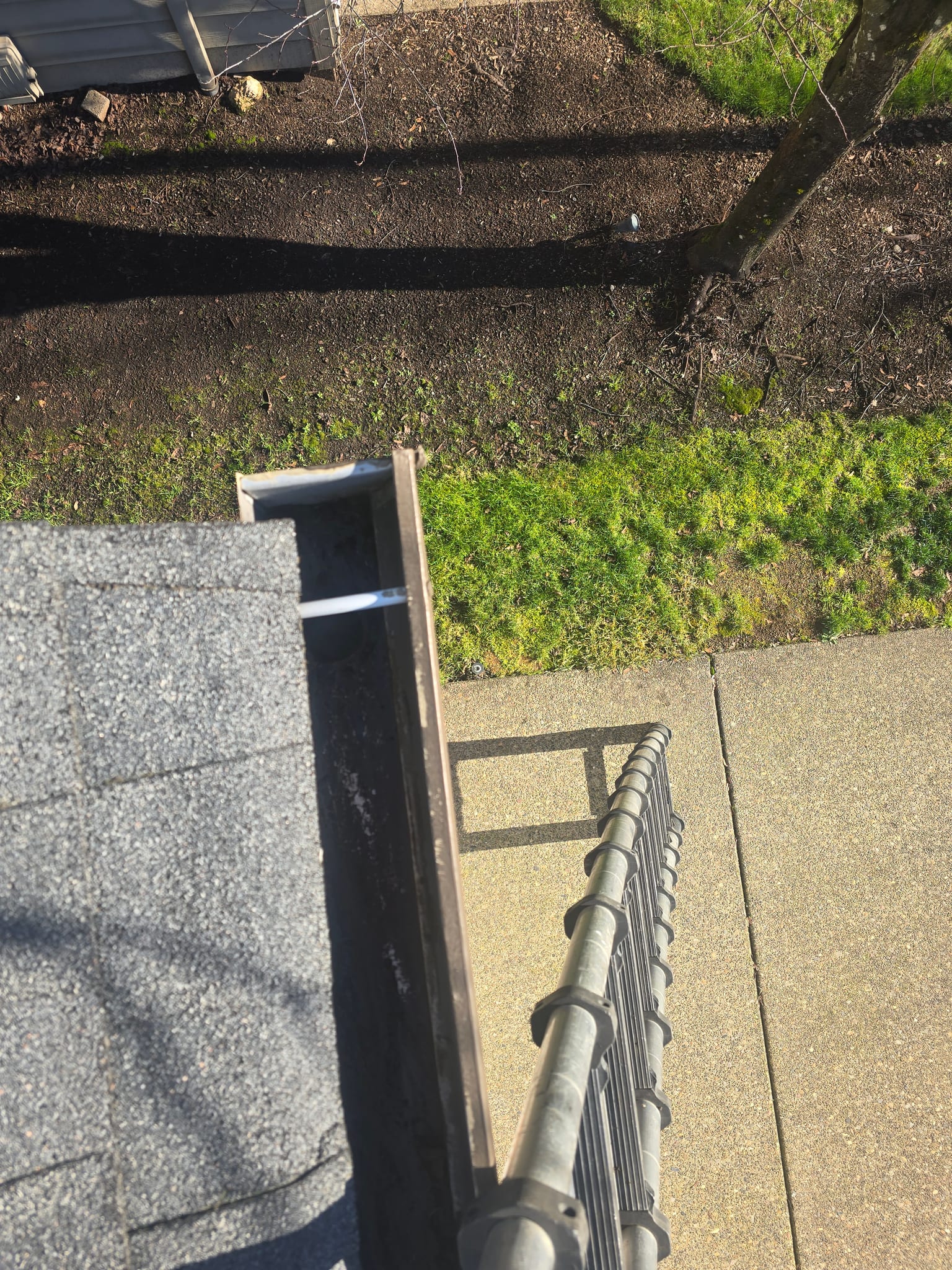 A cleared gutter seen from the top of the ladder after cleaning
