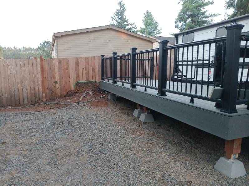 New cedar privacy fence beside a composite deck with a black aluminum railing in Salem, Oregon, built by On Top Home Services and affiliates
